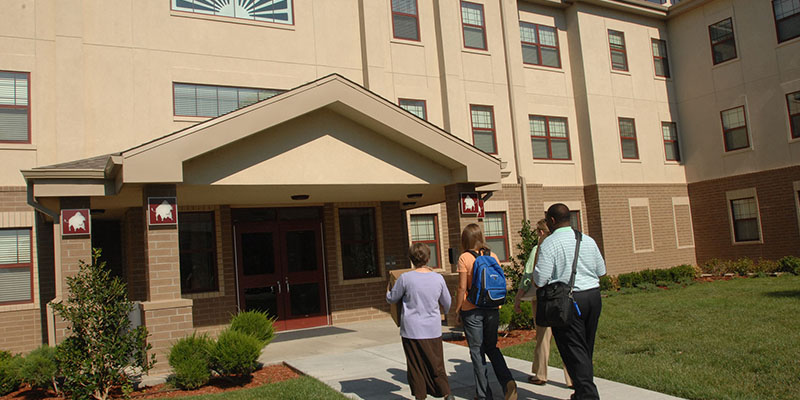 student and family outside residence hall 